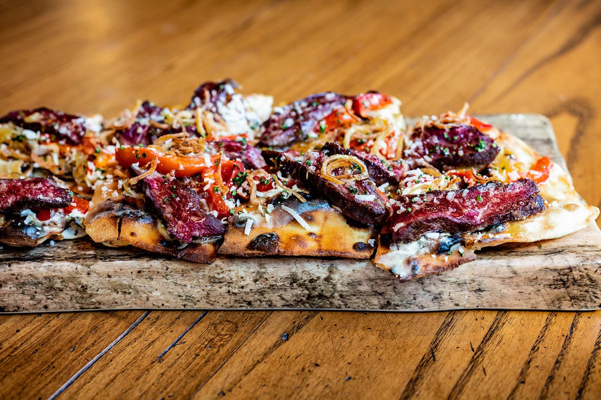 a slice of pizza sitting on top of a wooden cutting board